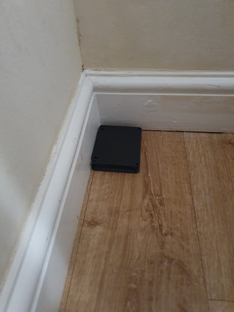 Insect monitor by skirting boards monitoring for bed bug activity in a bedroom with infestation at a property in Lewes Insect monitor by baseboards